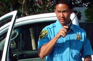 TLG Private Security Guard on Radio With Security Patrol Vehicle